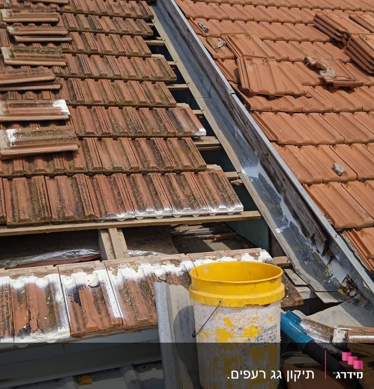 תיקון גג רעפים עם דליים וכלים